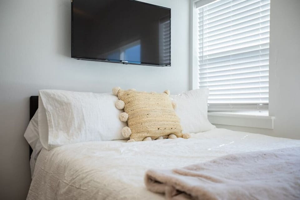 Cozy bedroom with queen bed and mounted TV