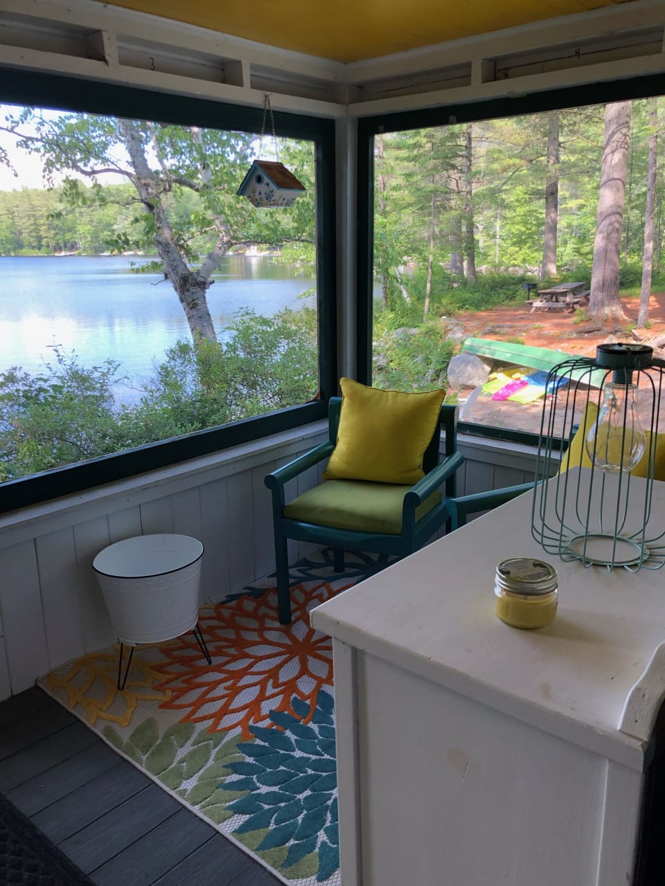 Private covered front porch with dining table and lake view.