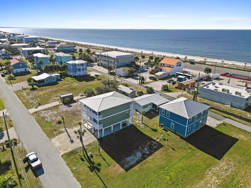 Coastal community featuring colorful beach houses just steps from pristine sandy shores and Gulf waters.