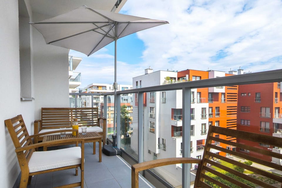 Another angle of the balcony, showcasing its open and airy design with views of modern apartment buildings. A welcoming space for enjoying the outdoors.