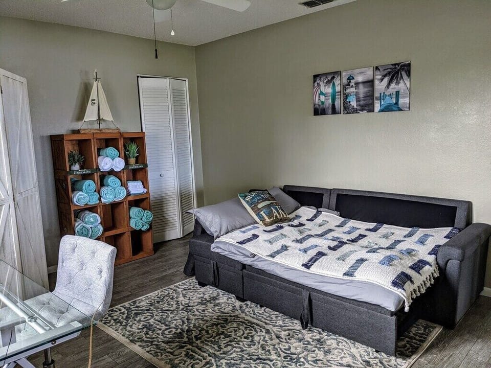 This area features a comfortable gray sofa bed, offering additional seating during the day and transforming into a cozy sleeping space at night.