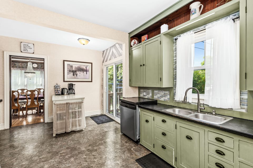 Kitchen sink with nice view of backyard, along with a dishwasher.