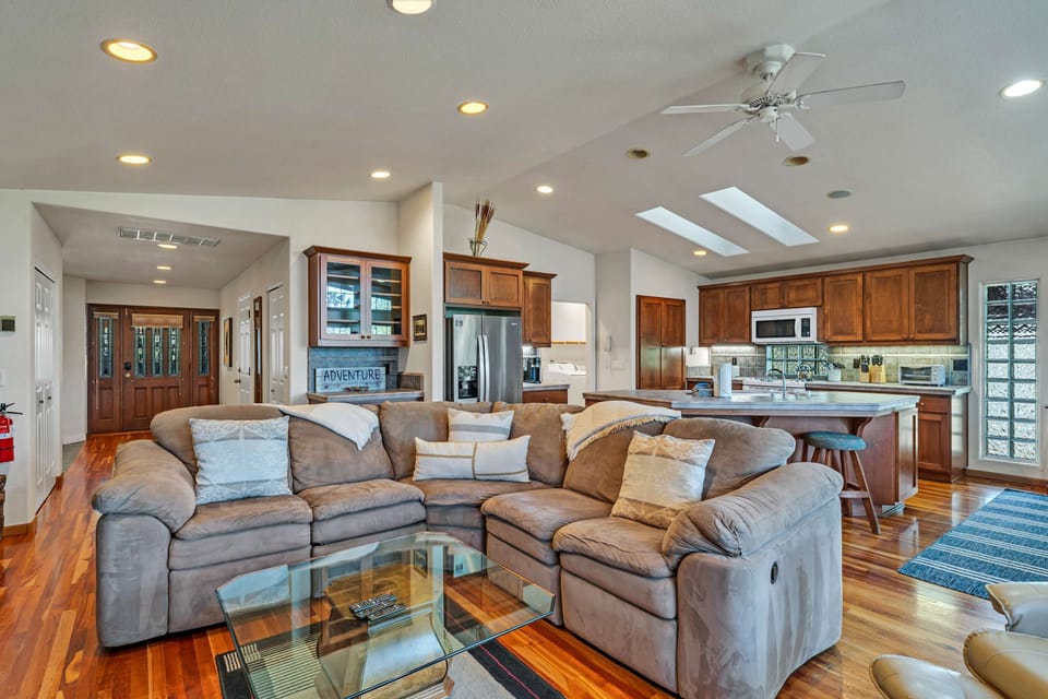 open and social living/kitchen/dining room is flooded with natural light thanks to the wall of soaring floor-to-ceiling windows.