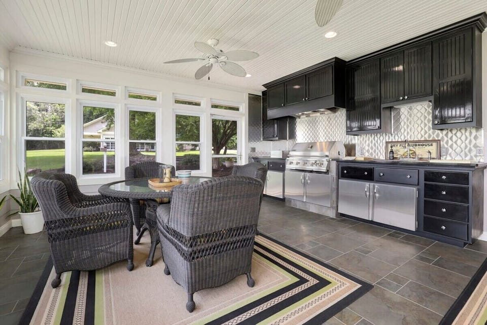 To the left, you'll see our 4-top dining table and to the right, you'll have access to our indoor grilling area, where you'll find a propane grill and fully stocked kitchenette.