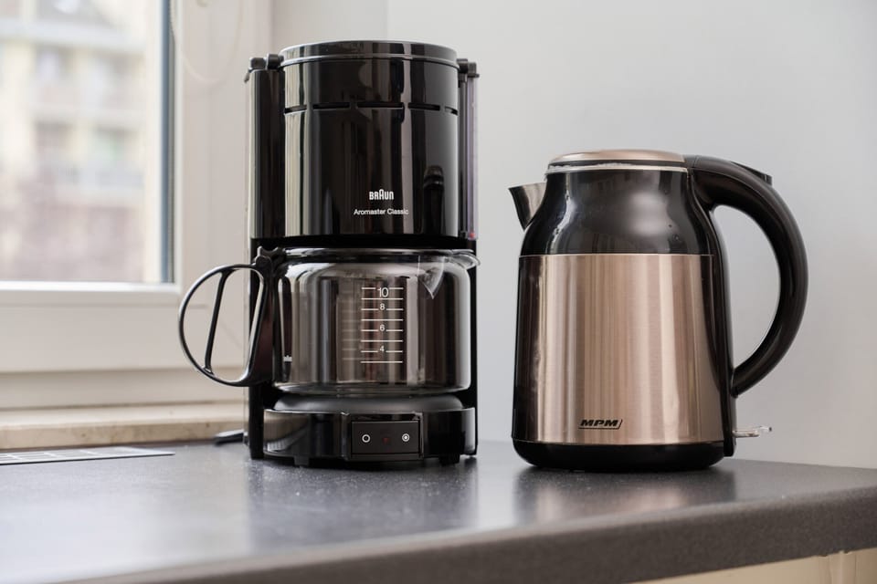 A close-up of a coffee maker and electric kettle on the kitchen counter, ensuring convenience for guests.
