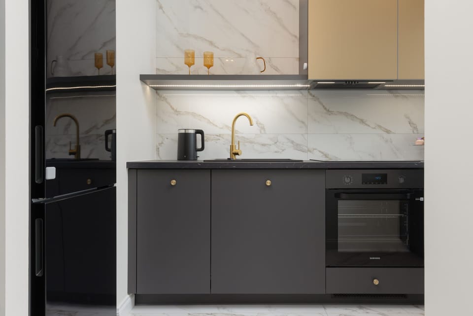 A modern kitchenette with dark furniture and space that provides room to prepare home-cooked meals.