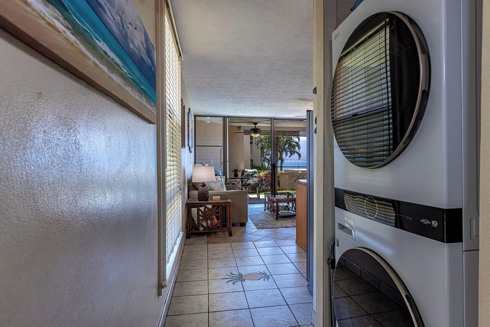Convenient in-unit washer and dryer keep your vacation wardrobe fresh, while the breezy hallway opens to a cozy living area with stunning ocean views beyond.