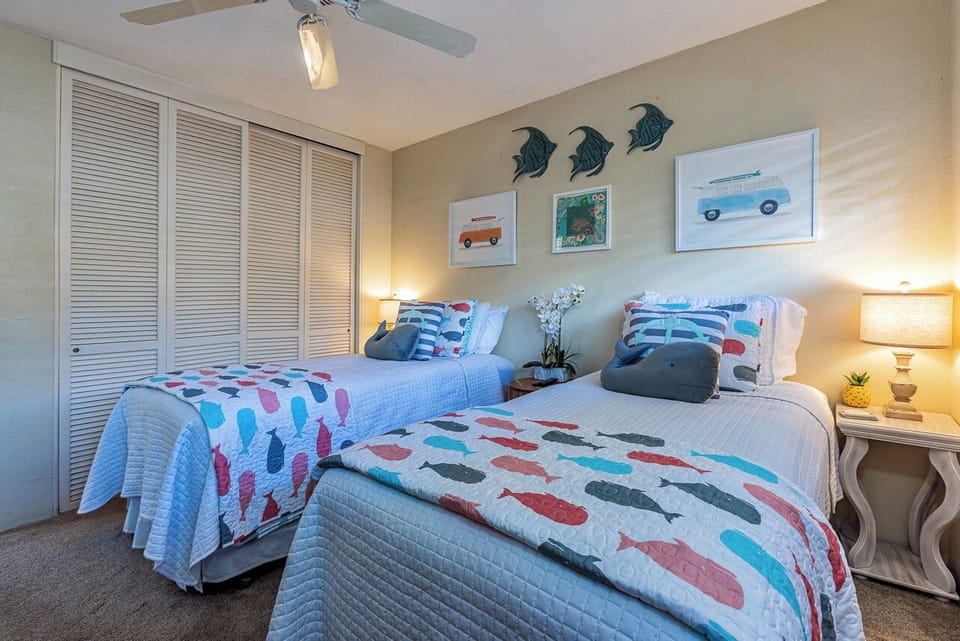 Rest easy in this cheerful beach-themed bedroom with two cozy beds, playful coastal décor, and soft lighting that sets the perfect tone for your seaside getaway.