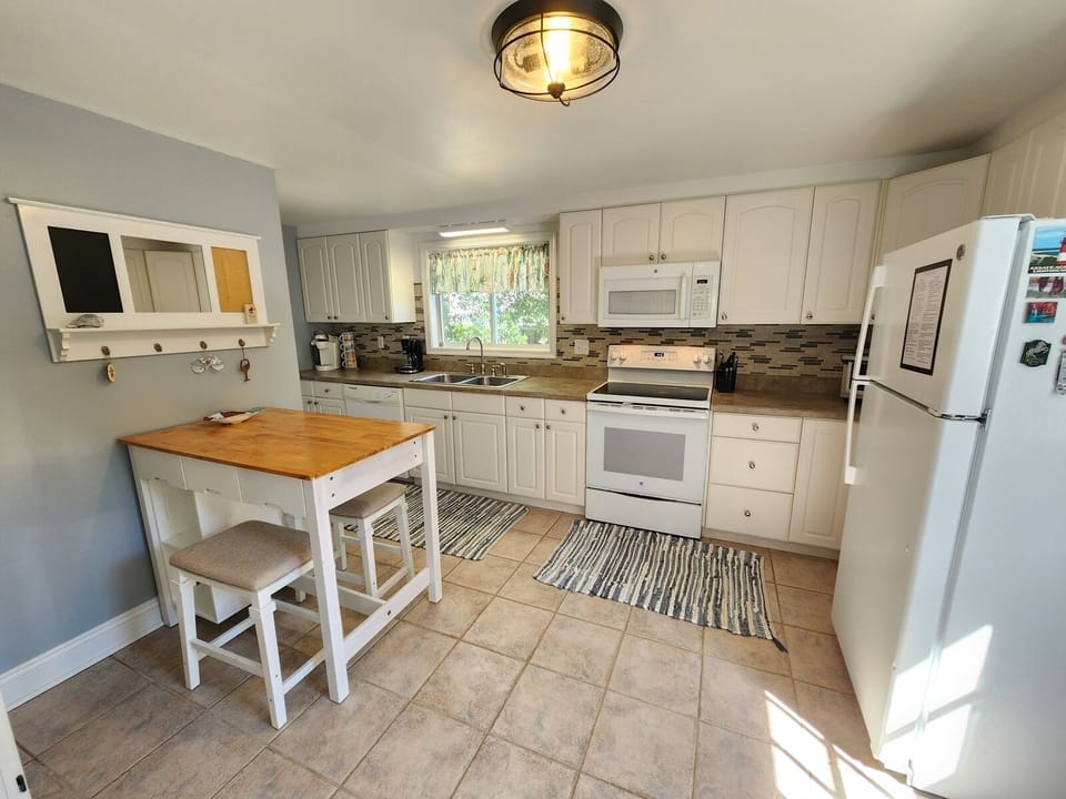 Fully equipped kitchen with dining area perfect for quick bites and morning coffee.