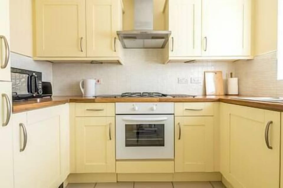 Clean practical kitchen with microwave, toaster and kettle. 