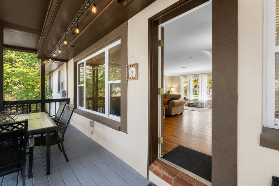 Covered patio entrance with outdoor dining space and seamless indoor-outdoor living.