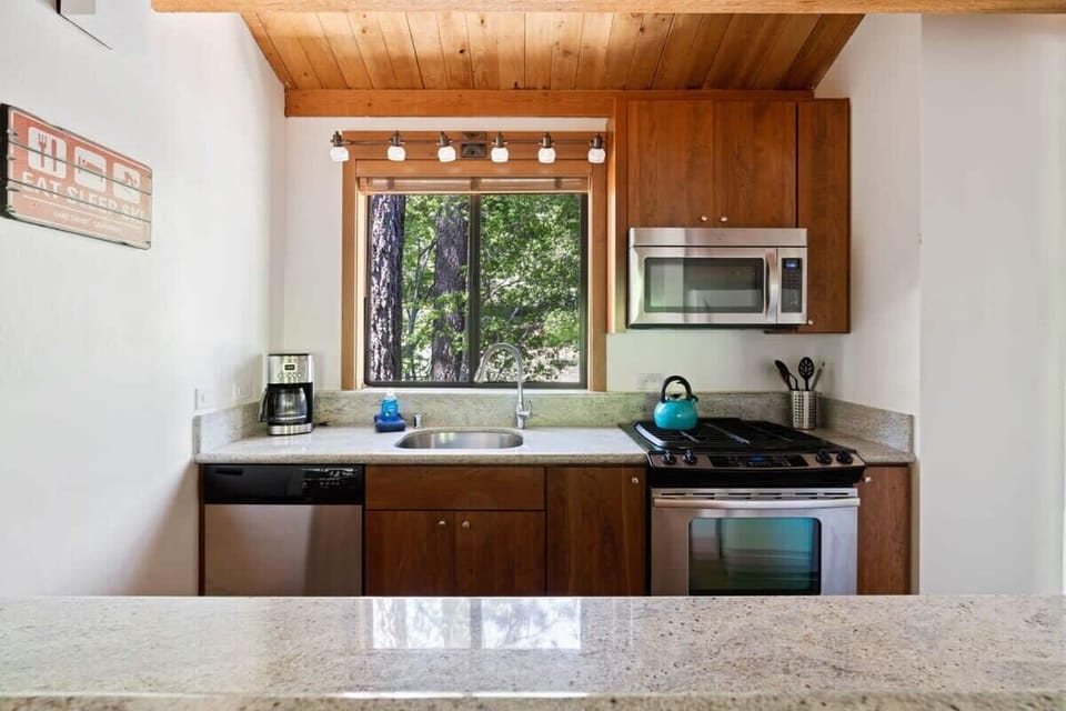 Enjoy the view out the kitchen window over the surrounding trees while you do dishes or meal prep on the spacious countertops