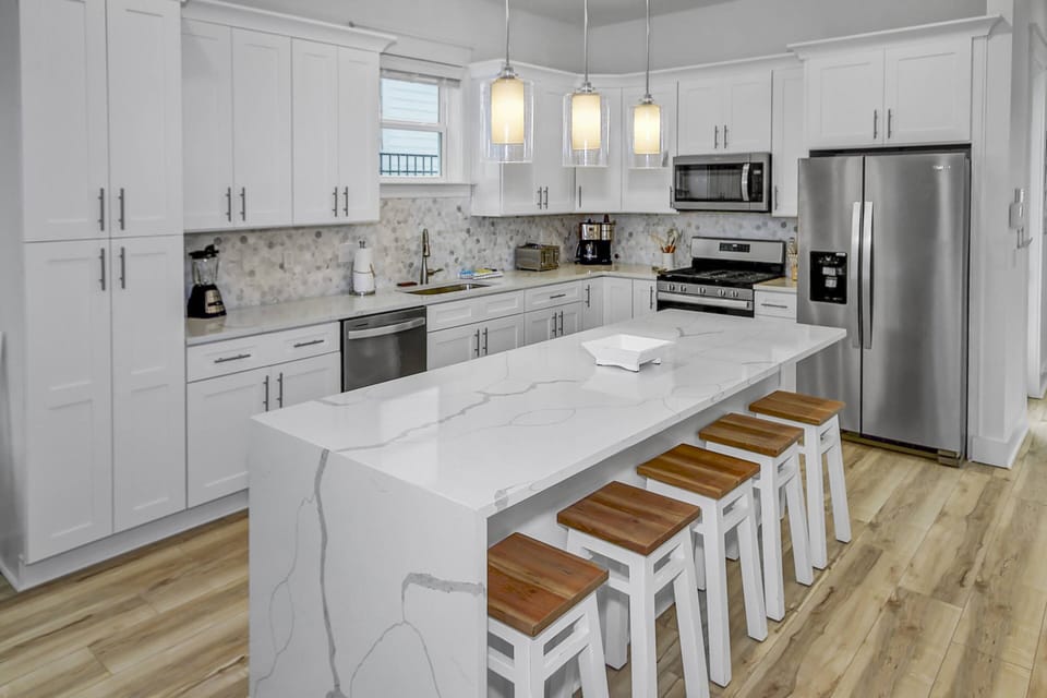 The well appointed kitchen offers beautiful quartz counter-tops, stainless appliances and 5 additional seats at the expansive kitchen island