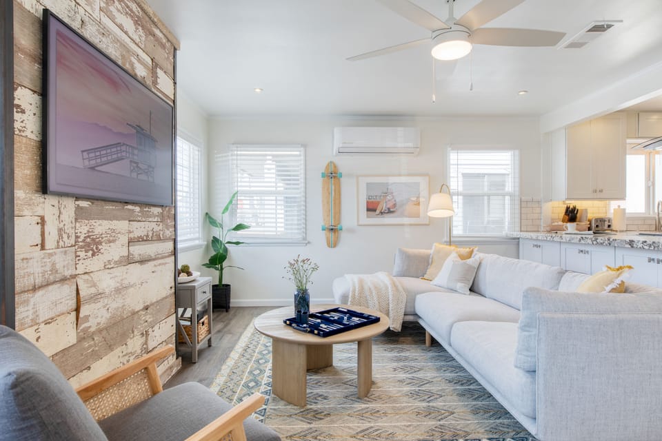 Living room at Surfrider I features stone detailing, a comfortable couch, and a large TV.