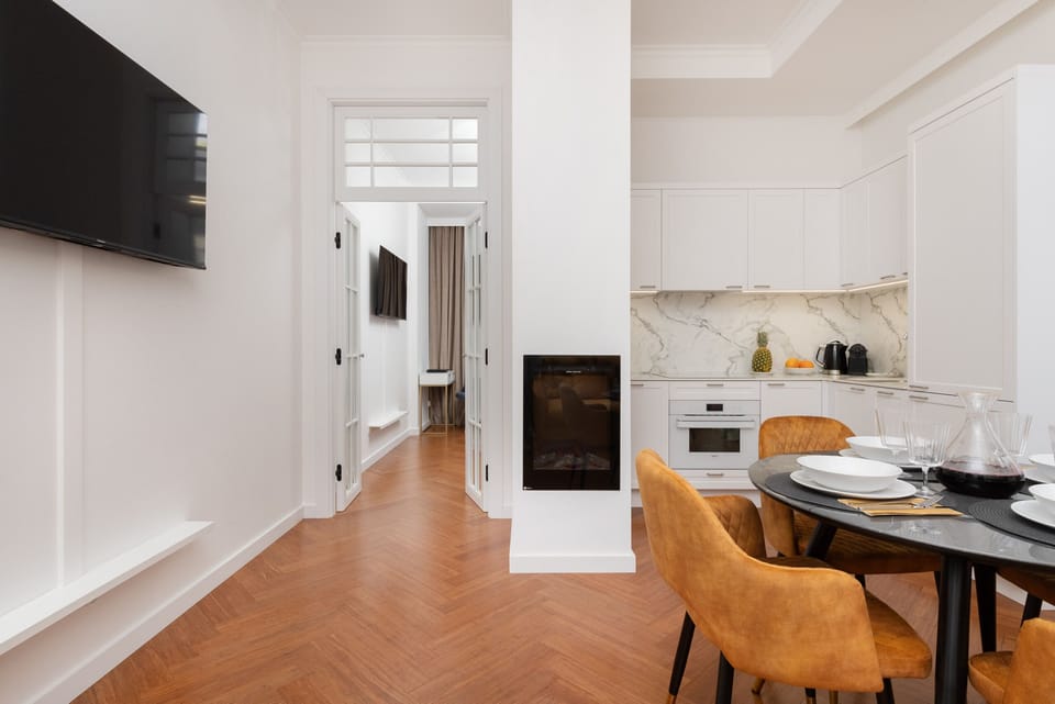A hallway view connecting the kitchen, dining, and living areas, emphasizing the apartment's spacious layout.
