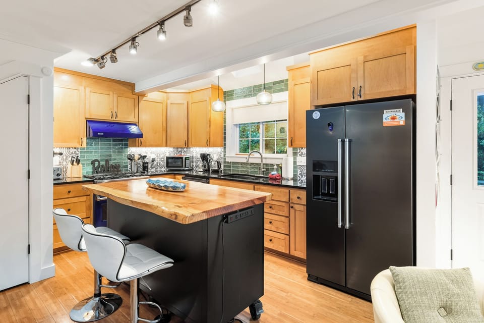 Fully equipped kitchen including a Viking Gas range, Breakfast Bar, Dishwasher, Microwave. Open to the dining area with 5 additional seats.