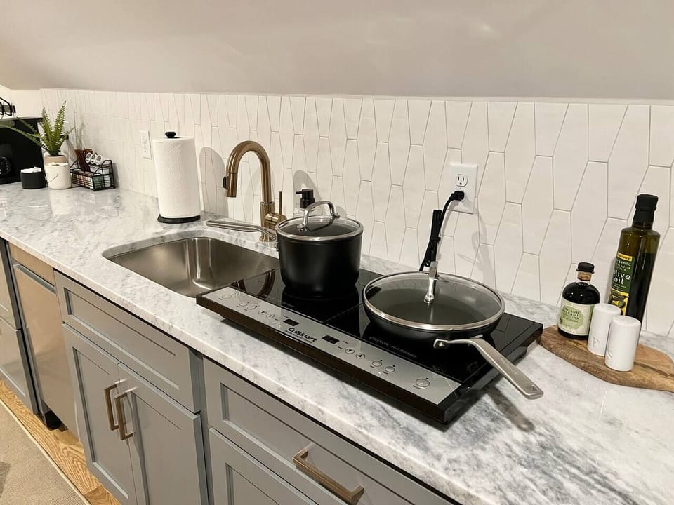 This induction cook top allows cooking with pots and pans like a normal kitchen, but can be stowed away in the cabinet when not in use to free up countertop space.