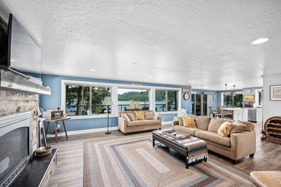 Relax in your spacious open-plan living area with stunning lake views through floor-to-ceiling windows, perfect for unwinding after a day of adventure.