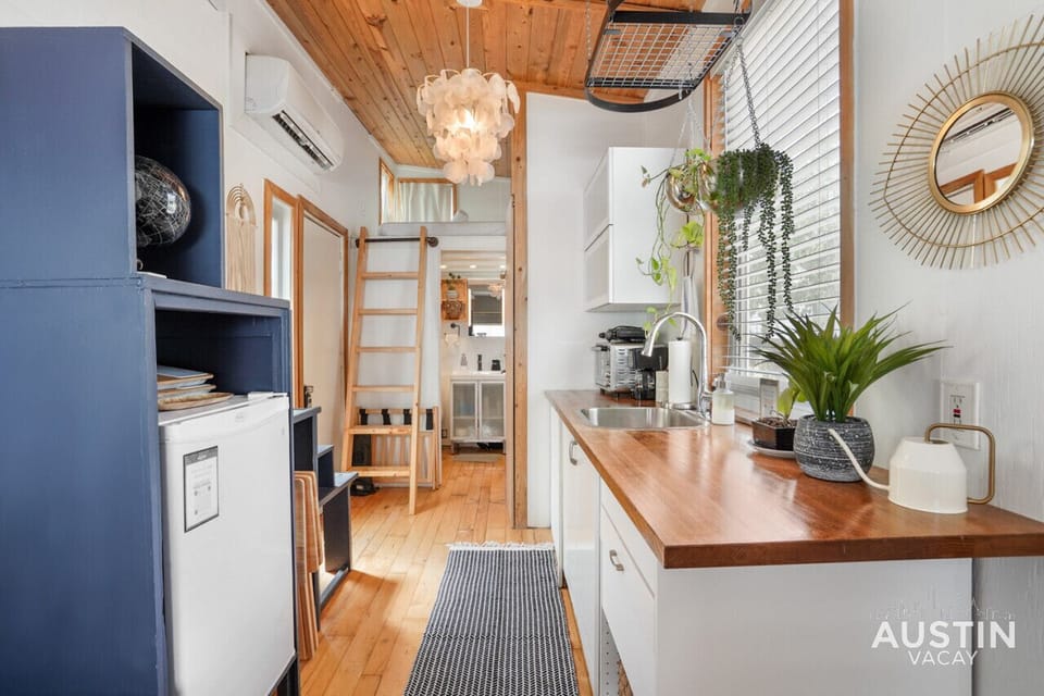 Kitchen with hot plate, toaster oven, coffee machine, and refrigerator.