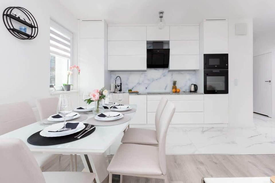 A full view of the kitchen and dining area, showcasing the clean, open-plan layout and modern finishes.
