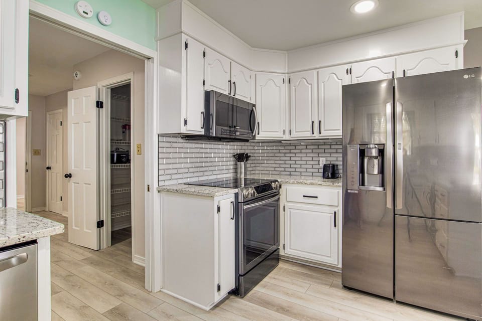 Kitchen with subway tile backsplash and stainless appliances at pet-friendly Gulf Breeze bayfront vacation rental home