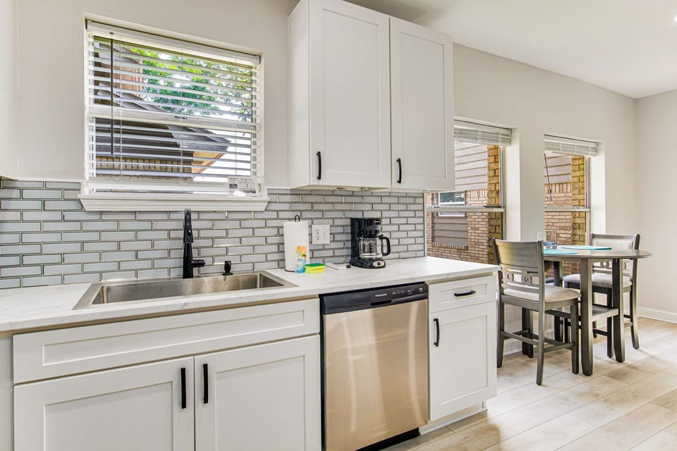 Modern kitchen with white cabinetry granite counters at Gulf Breeze bayfront house near Pensacola