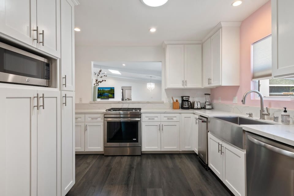 Kitchen with microwave, dishwasher, cooker, fridge, & utensils