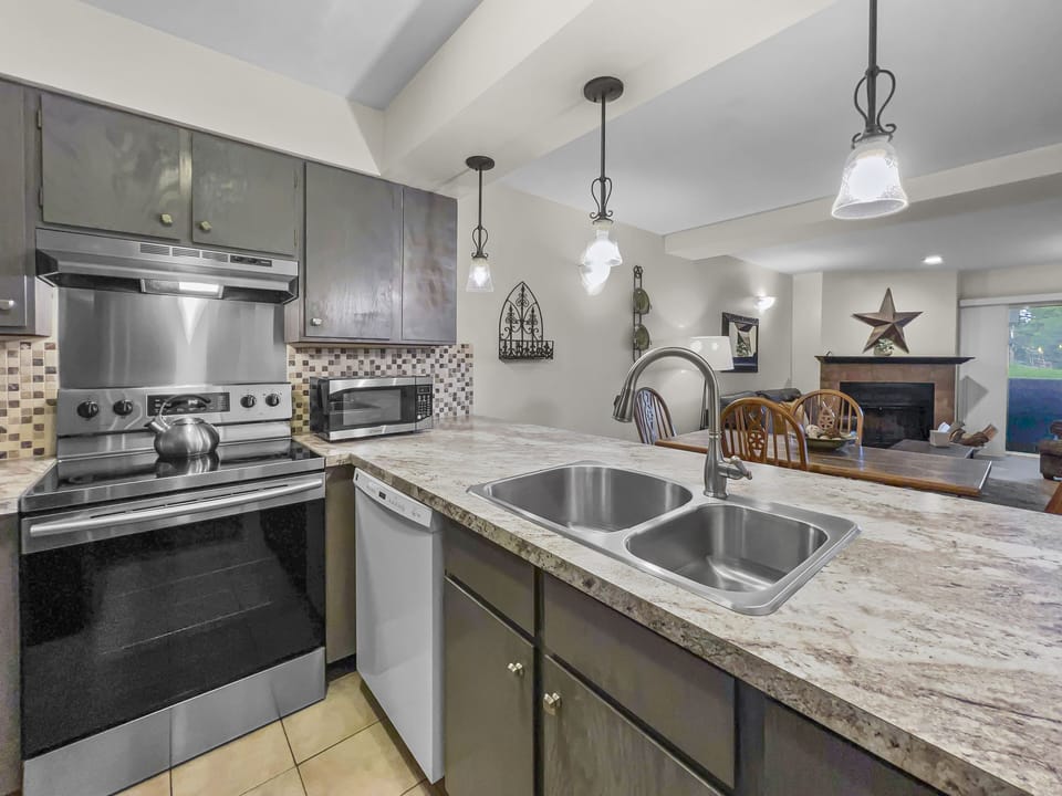 Prepare meals in our fully equipped kitchen, featuring stainless steel appliances, and modern white cabinets. All the essentials for a great stay.