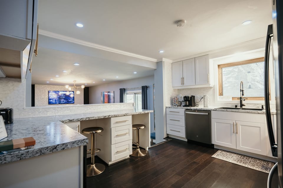 Fully equipped kitchen with island seating, modern appliances, and coffee bar, everything you need for group meals and morning coffee.