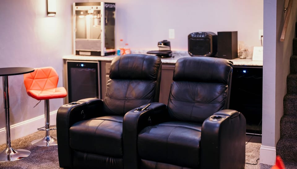 Private home theater with reclining seats, popcorn machine, and bar area, perfect for movie nights after a day exploring Door County.