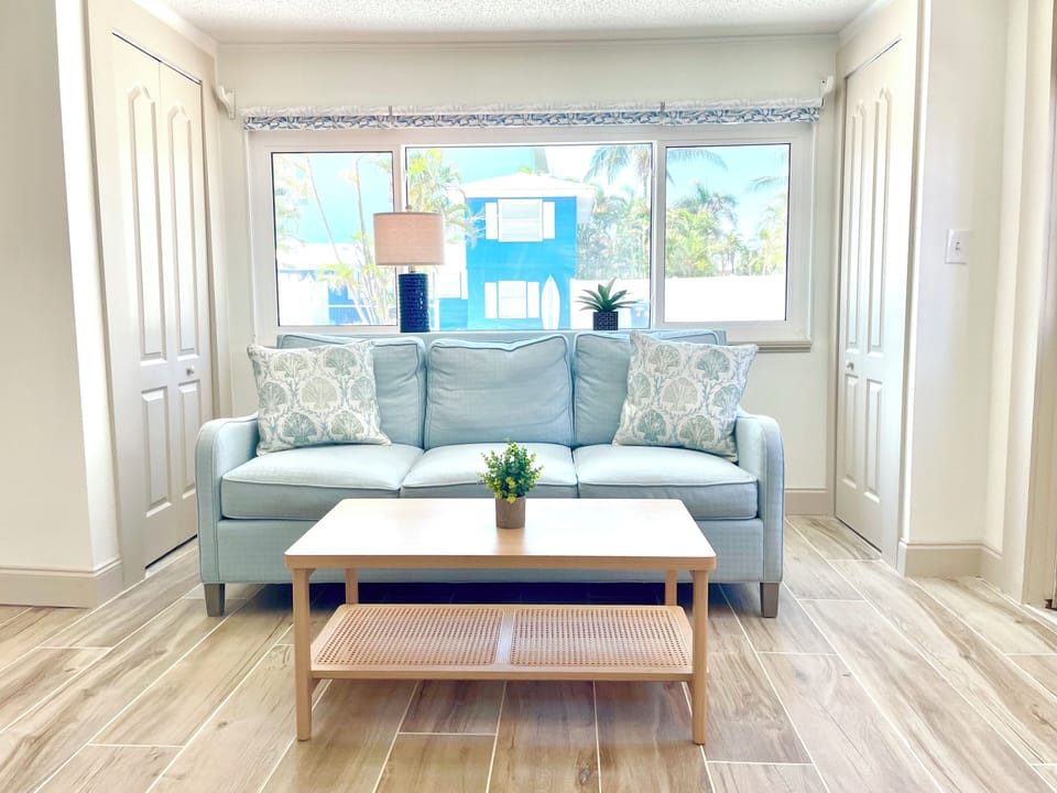 Bright living room with sofa, coffee table, and windows with natural light