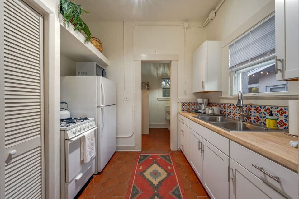 Kitchen with full-size fridge and freezer, stove, oven, and microwave