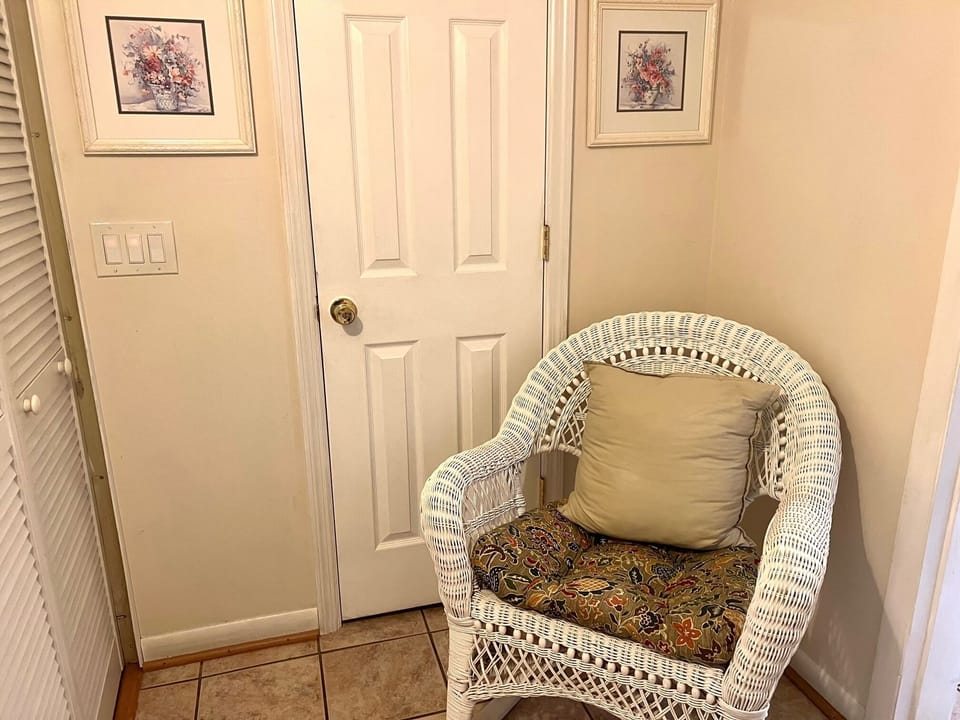 Take a moment to relax in the cozy white wicker chair, perfect for unwinding after a day out.