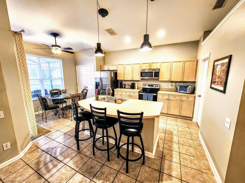 Open kitchen with Island prep and stainless steel appliances.
