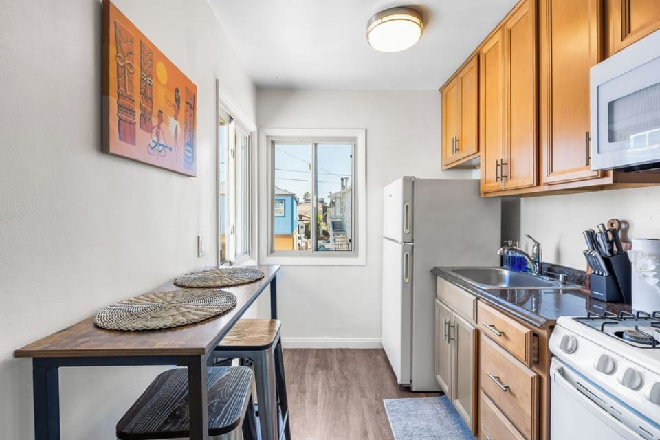 Kitchen - gas stove, microwave, fridge, blender, toaster, Keurig coffee maker, and coffee pods.