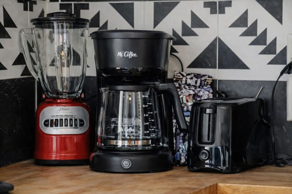 Coffee station with drip coffee maker, blender, toaster, and essentials for easy mornings.