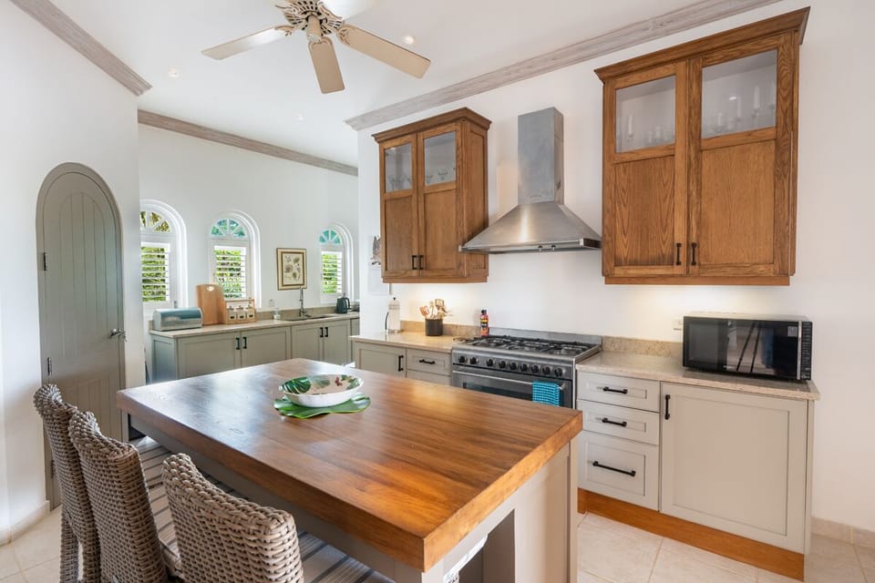 Sugar Hill-Fiddlesticks: The kitchen is complemented by a  six-burner stove, custom cabinetry, sleek wood and marble finishes