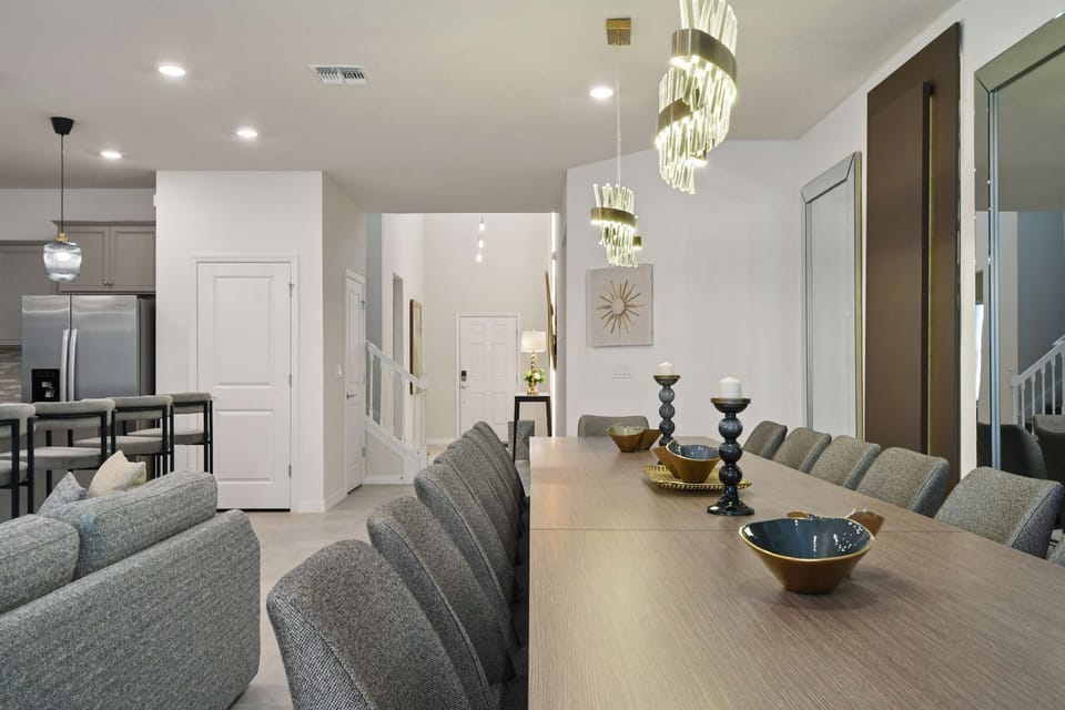 Modern dining area with sleek chandeliers, elegant table decor, and open layout.