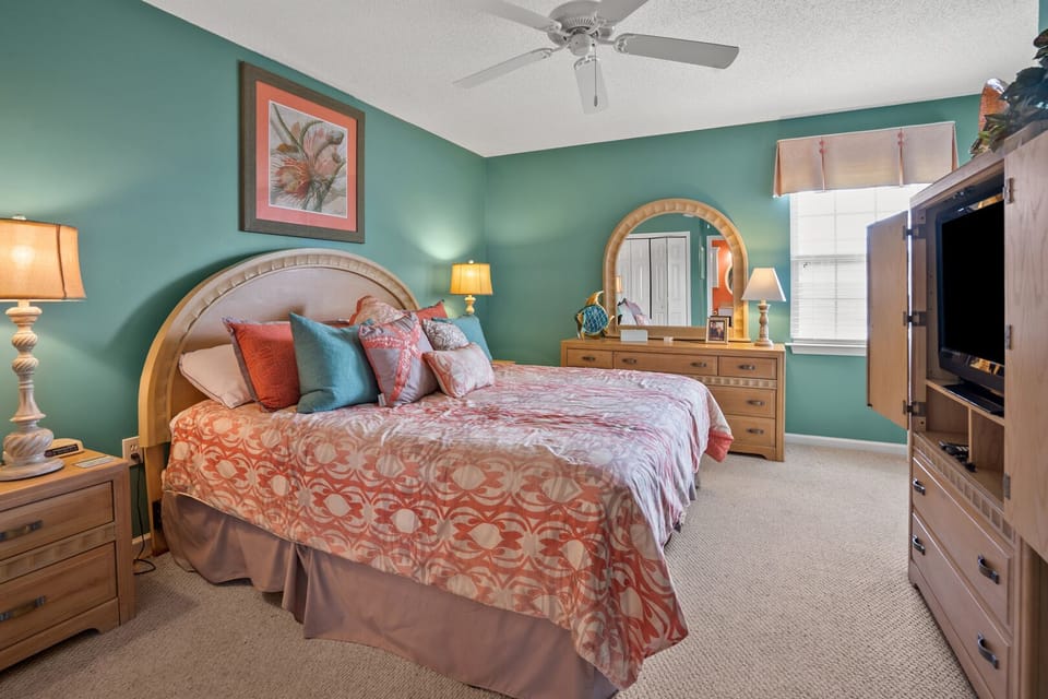 Bedroom with teal walls, a dresser and mirror at Ocean Pointe Villas 4B, a 3-bedroom Cherry Grove rental