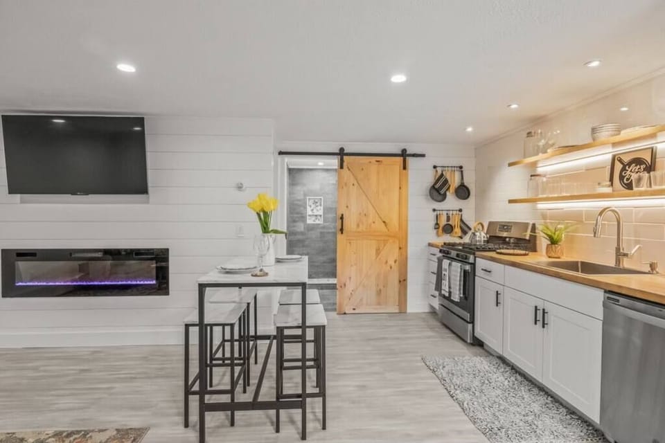 Electric fireplace, dining area and view to barn door