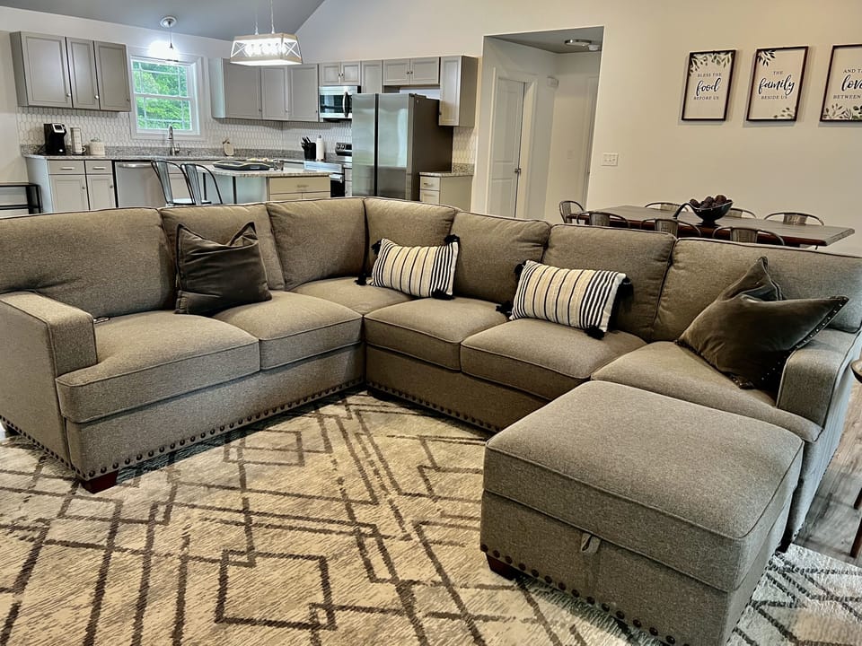 Comfortable sofa with ottoman to relax and watch on a 65" Smart TV.