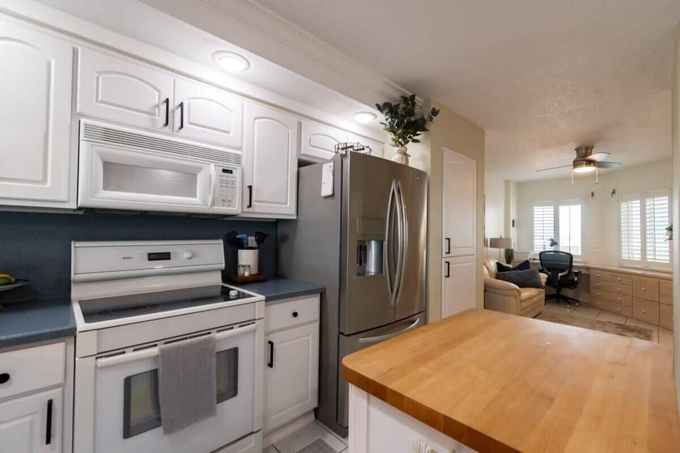Modern kitchen with stainless steel refrigerator and a cozy adjacent workspace.