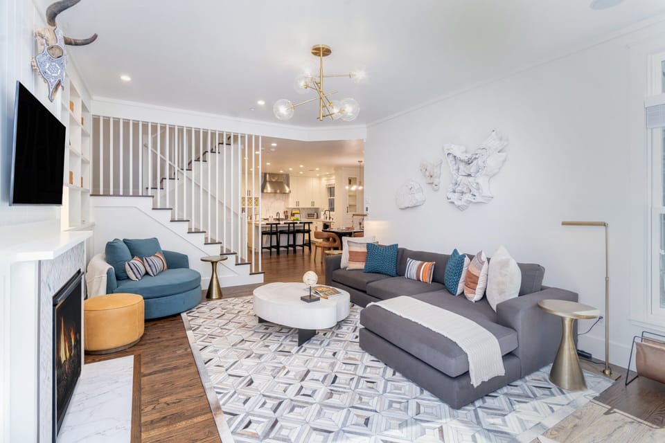 Spacious family room with reading chairs, large L-shaped couch and gas fireplace.