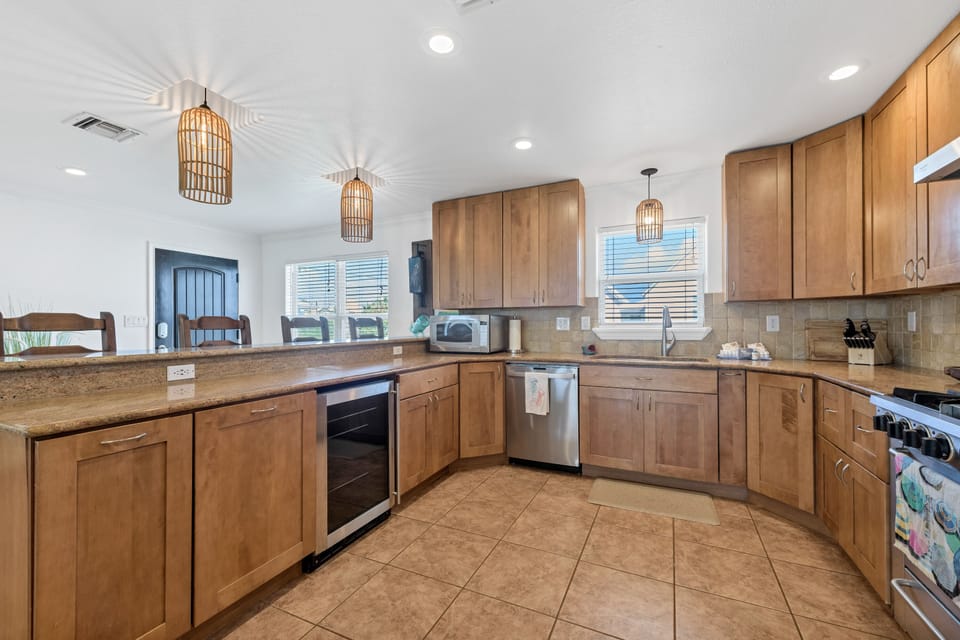 Your spacious kitchen invites culinary adventures with warm wood cabinetry, granite countertops, and modern appliances bathed in natural light.