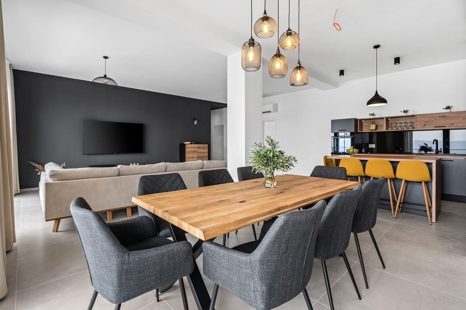 Spacious living/dining room with glass walls that give you a beautiful view of the sea and lots of daylight inside
