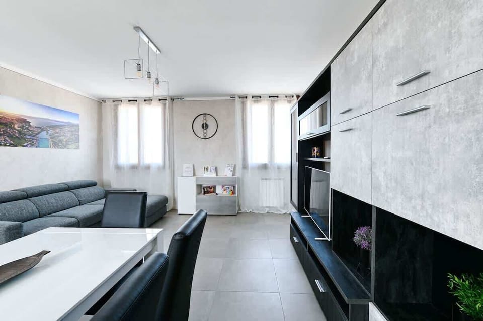 Zona Living con divano letto, mobile con Smart TV 55", tavolo da pranzo allungabile per 6 persone, climatizzatore Daikin