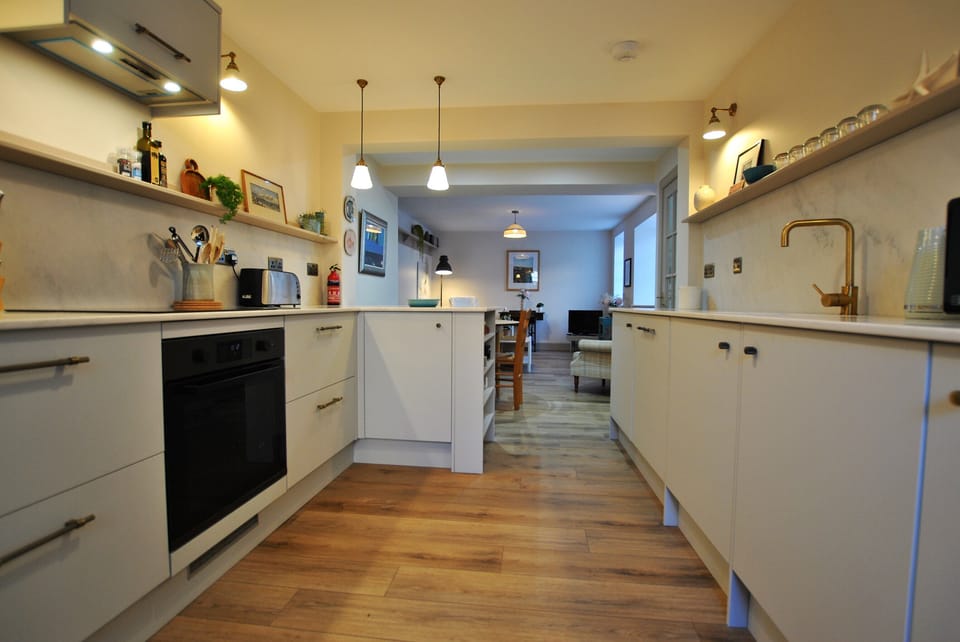 A fully fitted kitchen which leads to a dining area