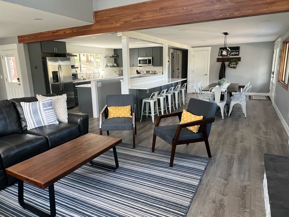 Living room opens to a large kitchen and dining area. Dining table seats 8