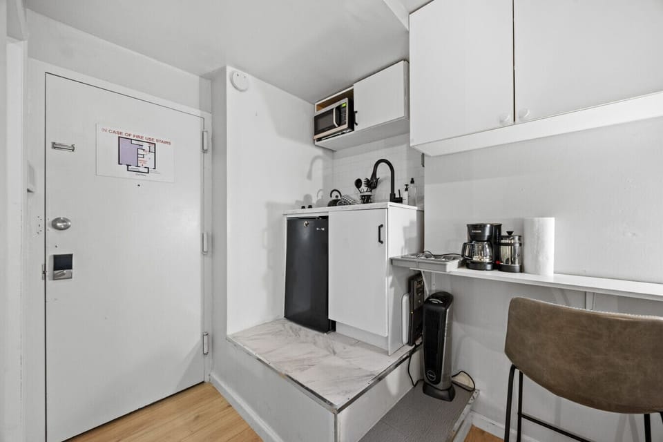 Stylish elevated kitchenette with a microwave and cooking essentials