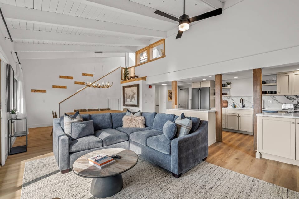 The heart of the home—an open-concept living area with stunning windows, loft, and deck.